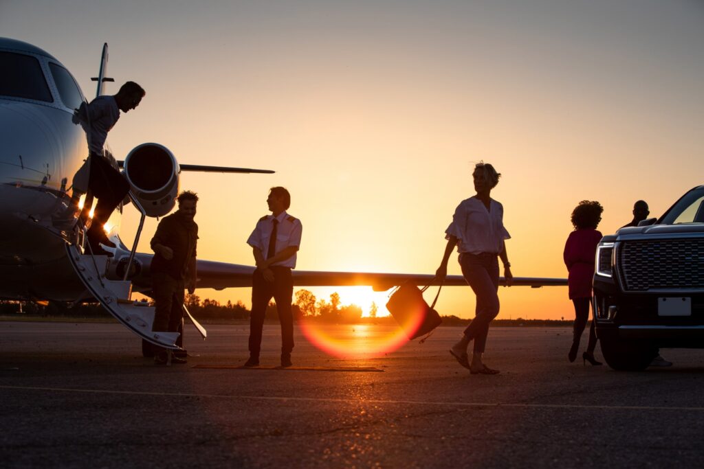 A group of corporate passengers leaving private jet during sunset