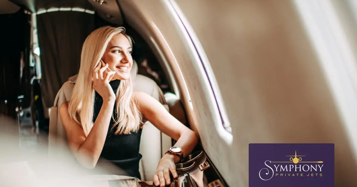 woman happily looking out of a chartered private jet window